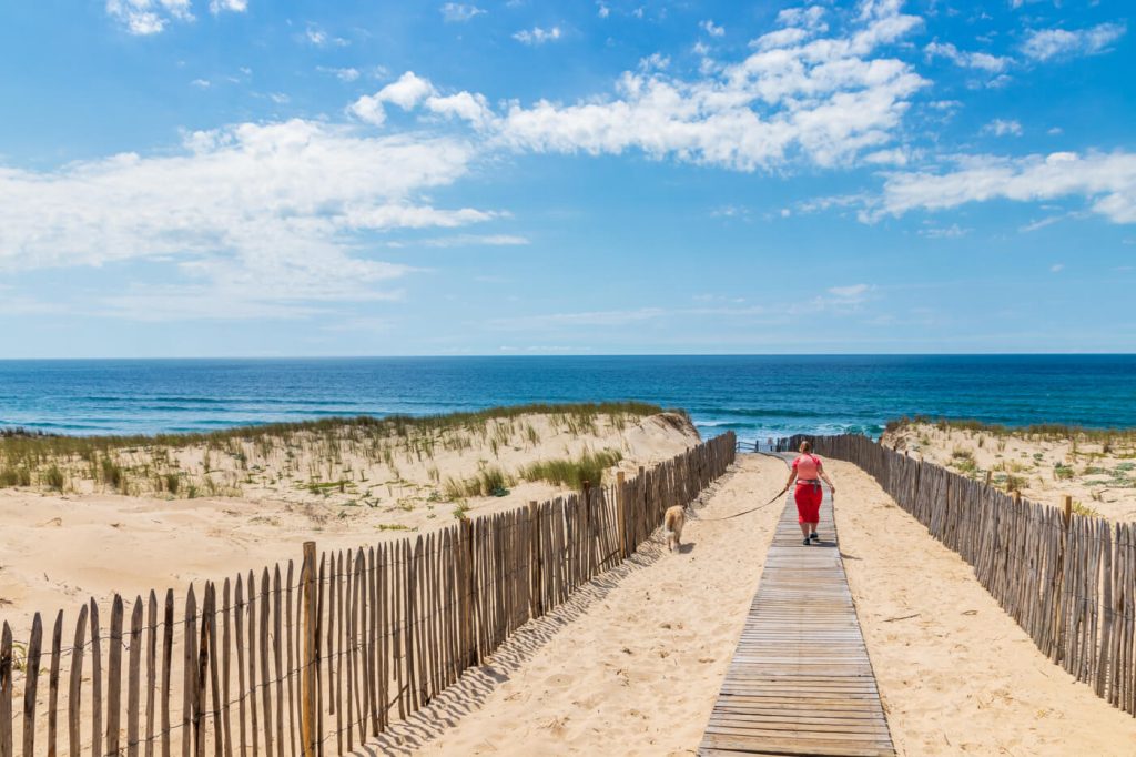 IMG_8882 Frau spaziert mit Hund am Strand von mimizian in Frankreich